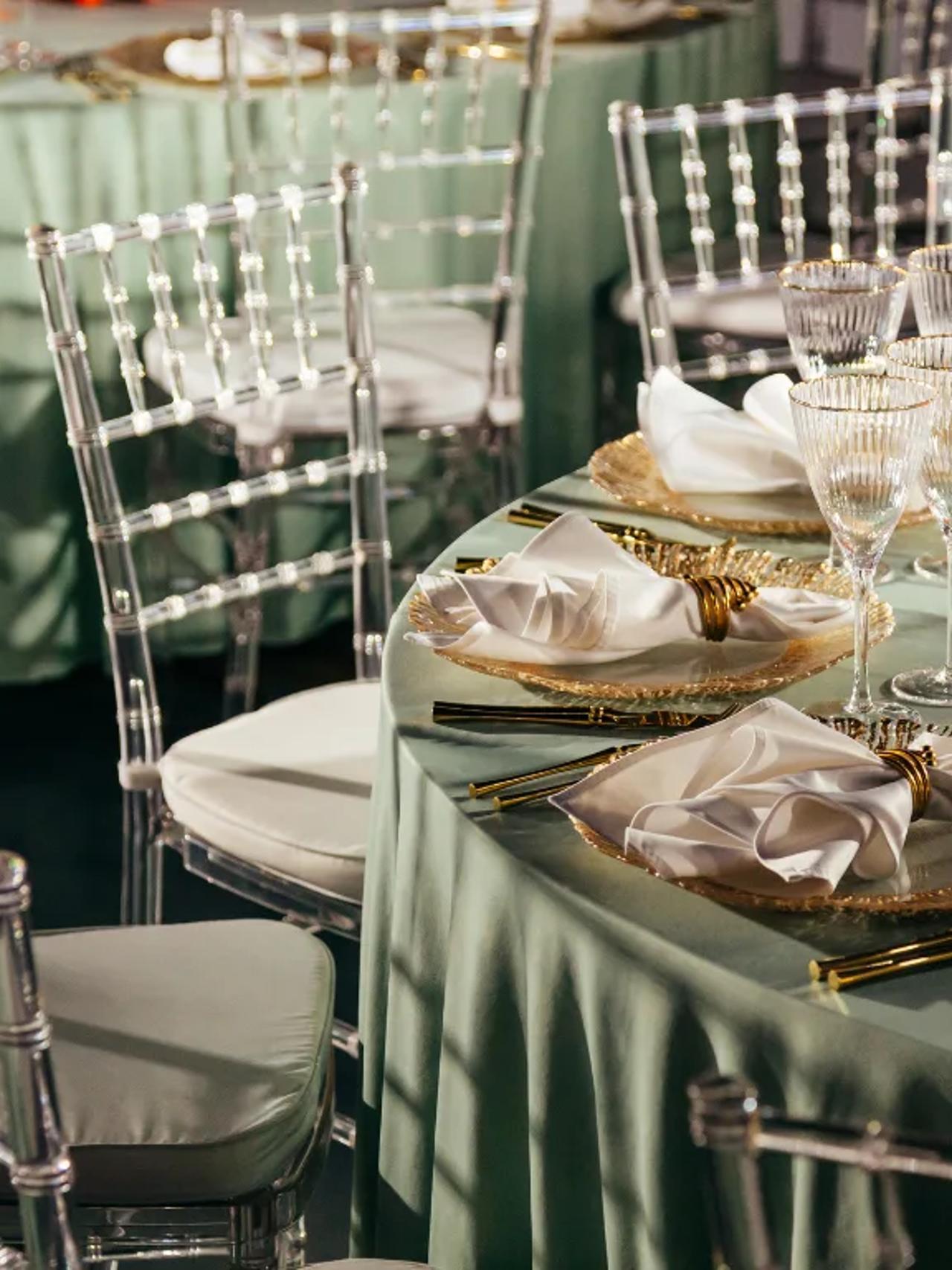 Elegant dining setup with green tablecloths and crystal glassware.