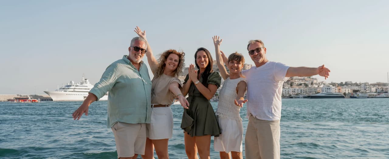 Grupo de personas posando frente al mar