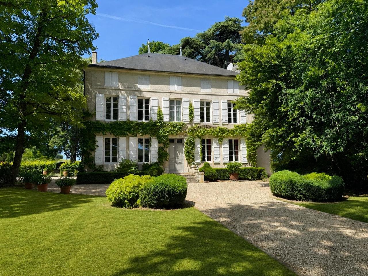 Villa élégante entourée de verdure luxuriante et de jardins bien entretenus.