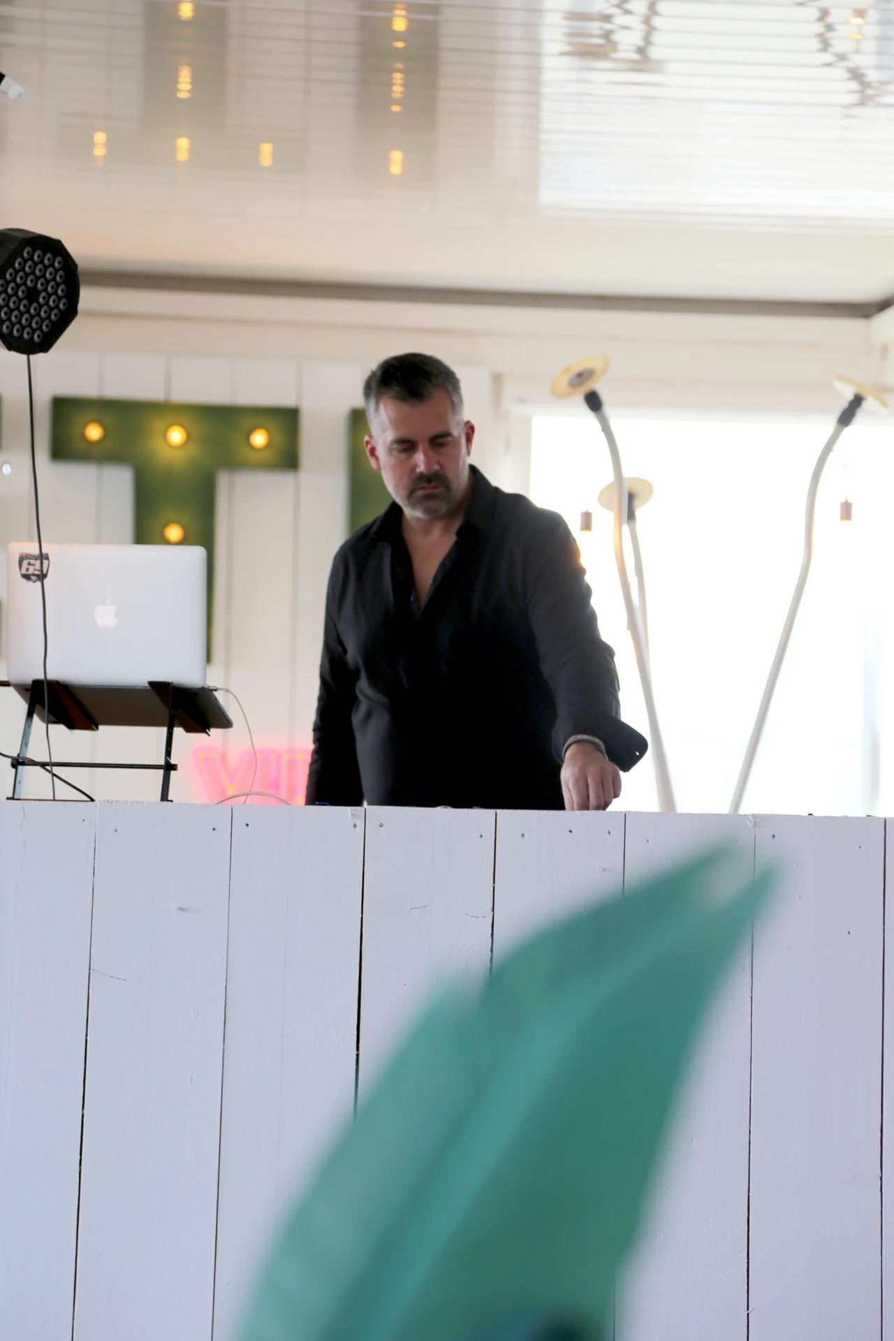 A man in a black shirt working at a restaurant bar.
