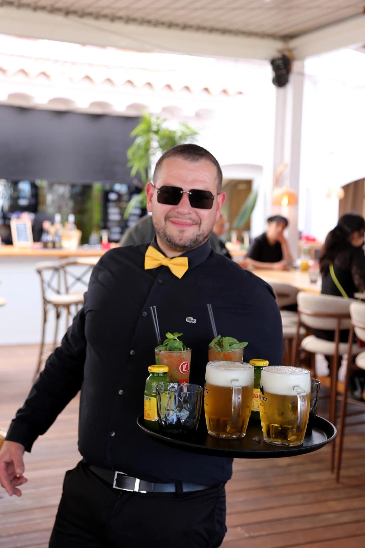 Waiter serving drinks on a tray at a restaurant