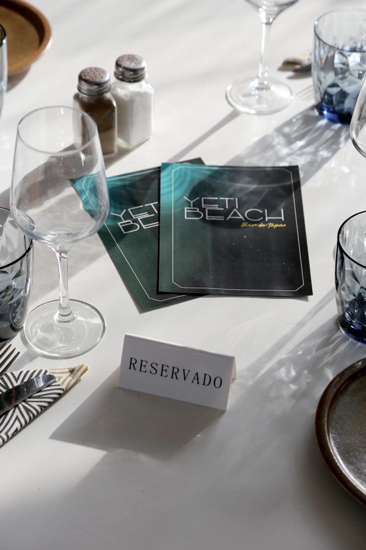 Reserved table setting at Yeti Beach restaurant with menus.