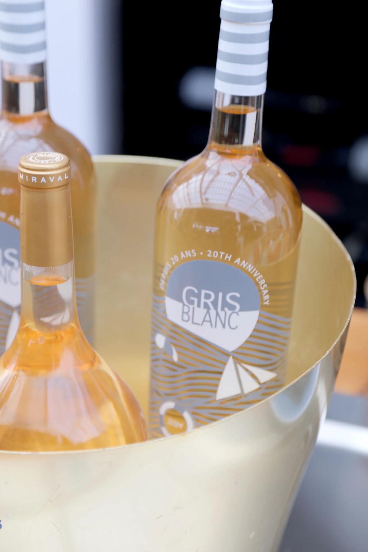 Chilled bottle of Gris Blanc wine in a gold ice bucket.