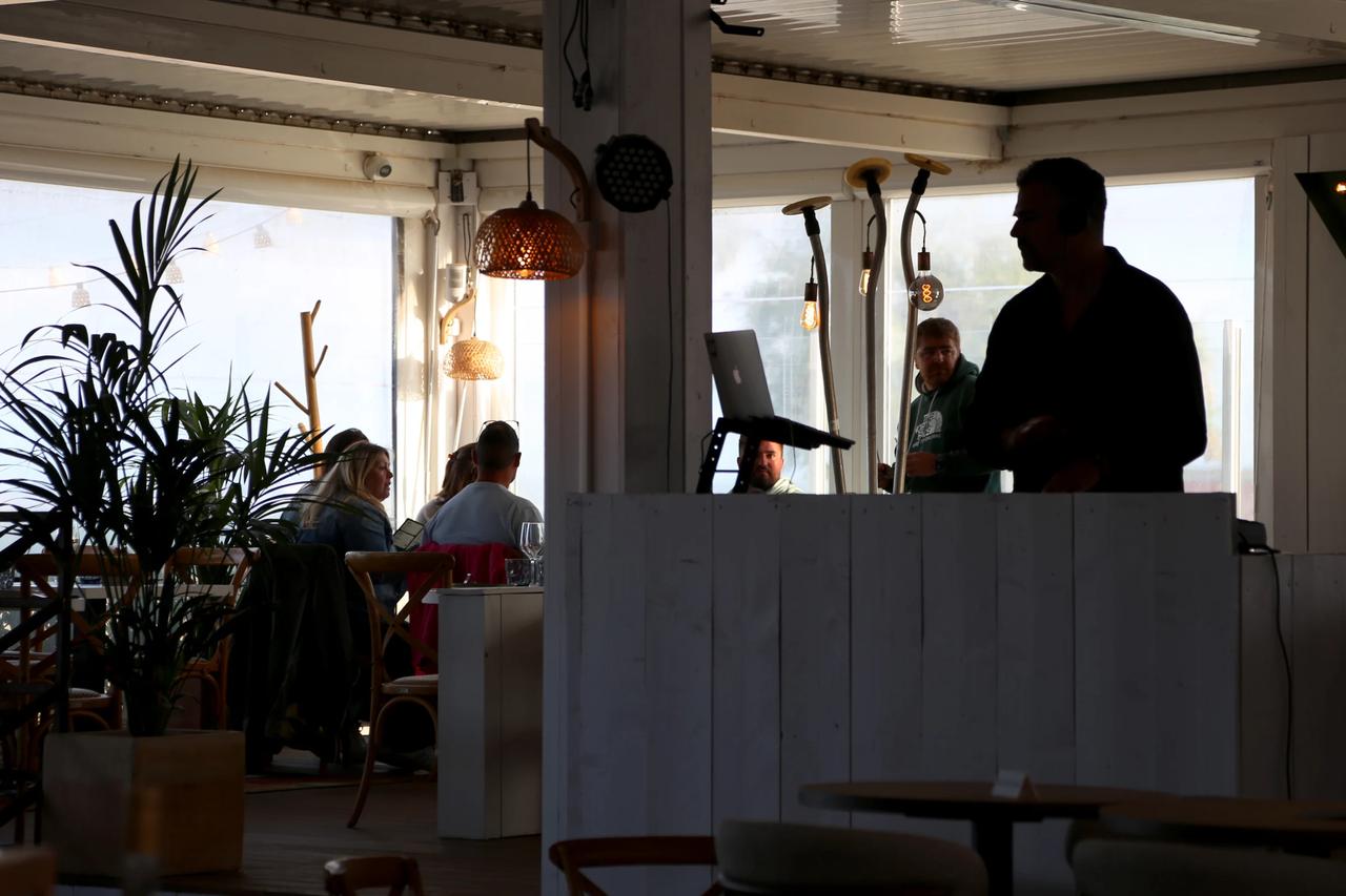 Interior of a restaurant with patrons and a DJ booth