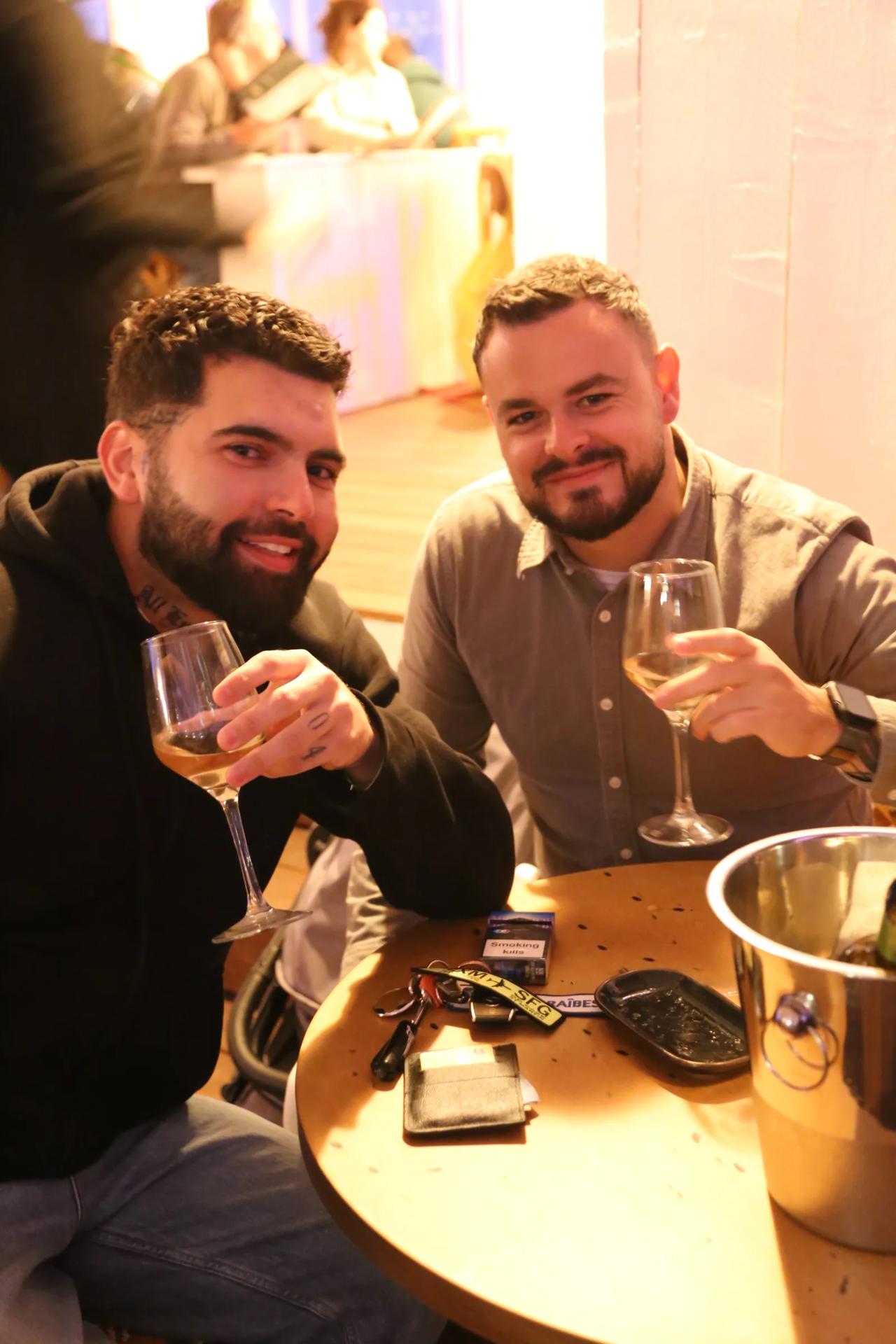 Two men toasting with glasses of wine at a restaurant.