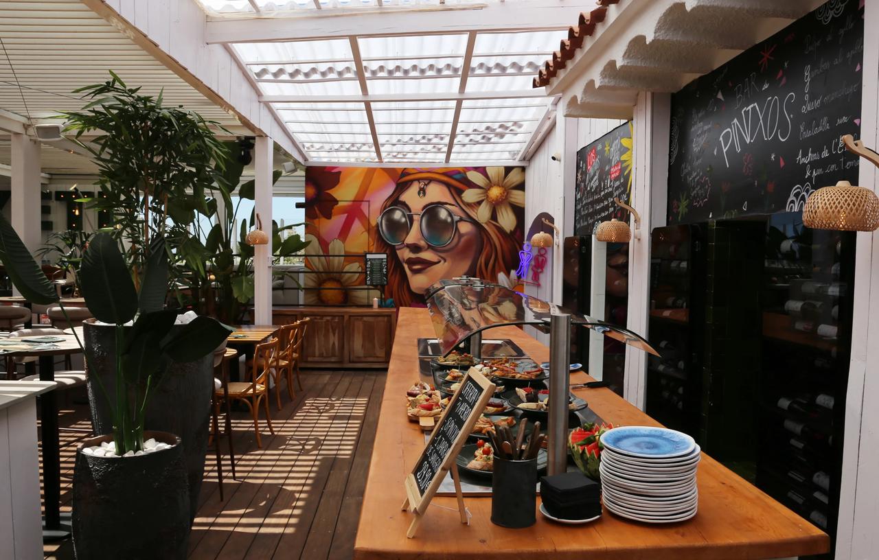 Interior view of a restaurant with a buffet and vibrant mural.