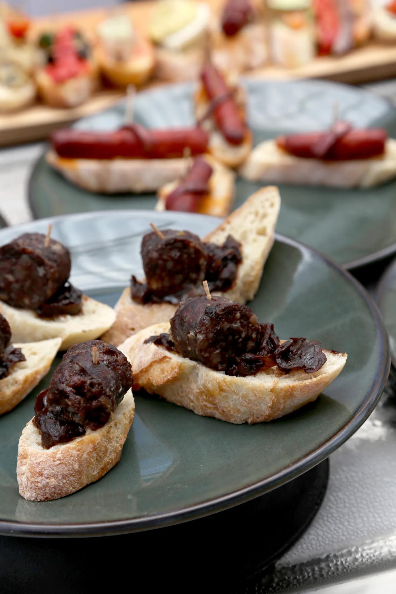 Sliced bread topped with black pudding and caramelized onions