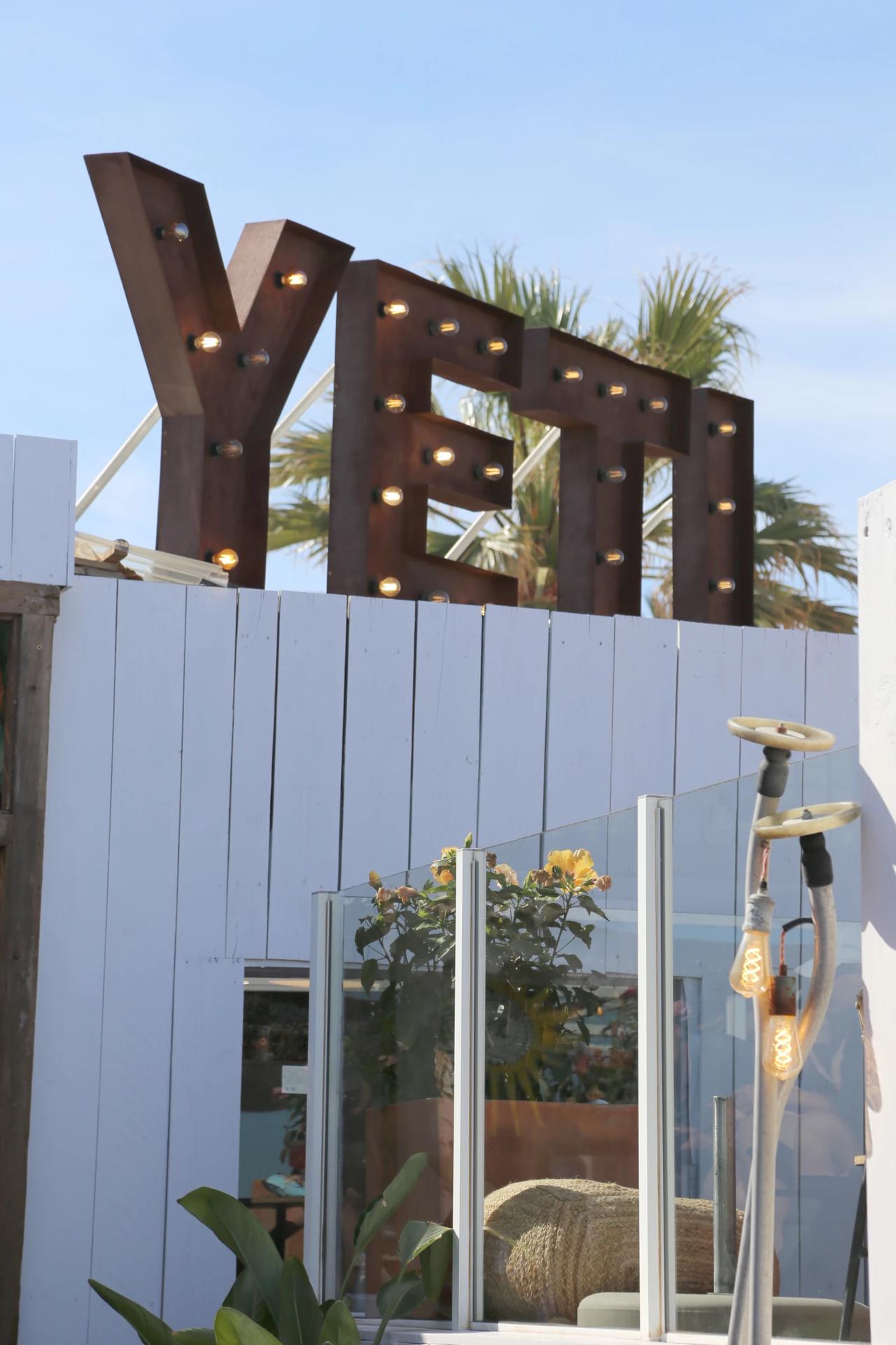 YETI restaurant sign with lights and palm trees in the background