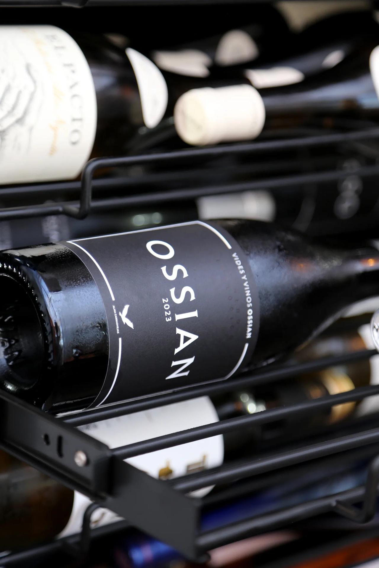 Bottle of Ossian wine on a rack among other bottles.