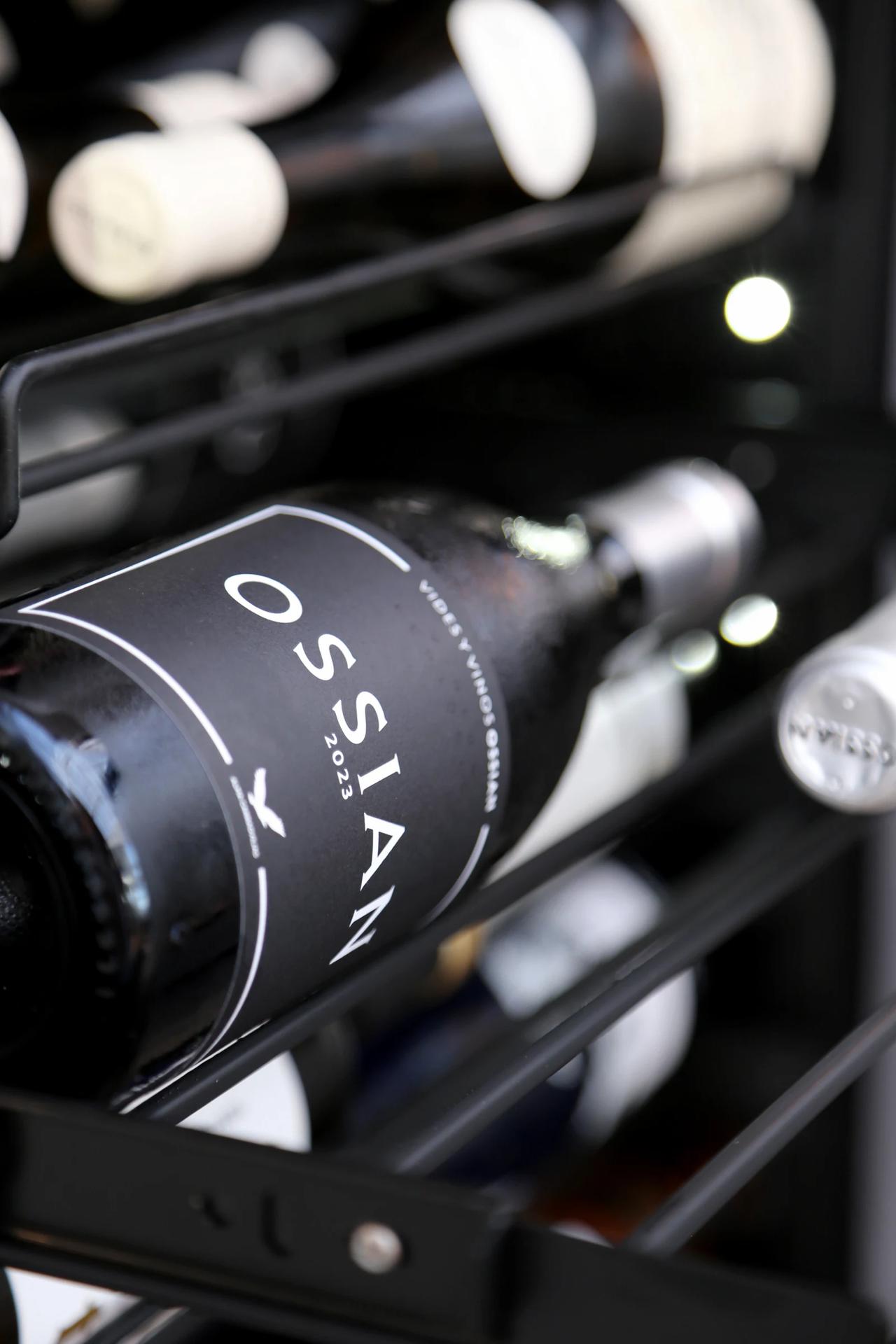 Close-up of a wine bottle labeled OSSIAN 2023 on a shelf.