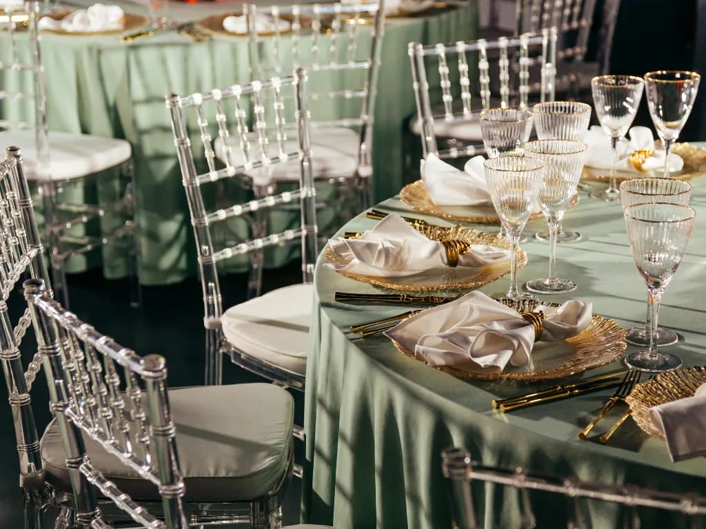 Elegant dining setup with green tablecloths and crystal glassware.