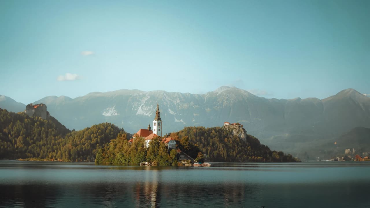 Scenic view of Bled Island with mountains in the background.