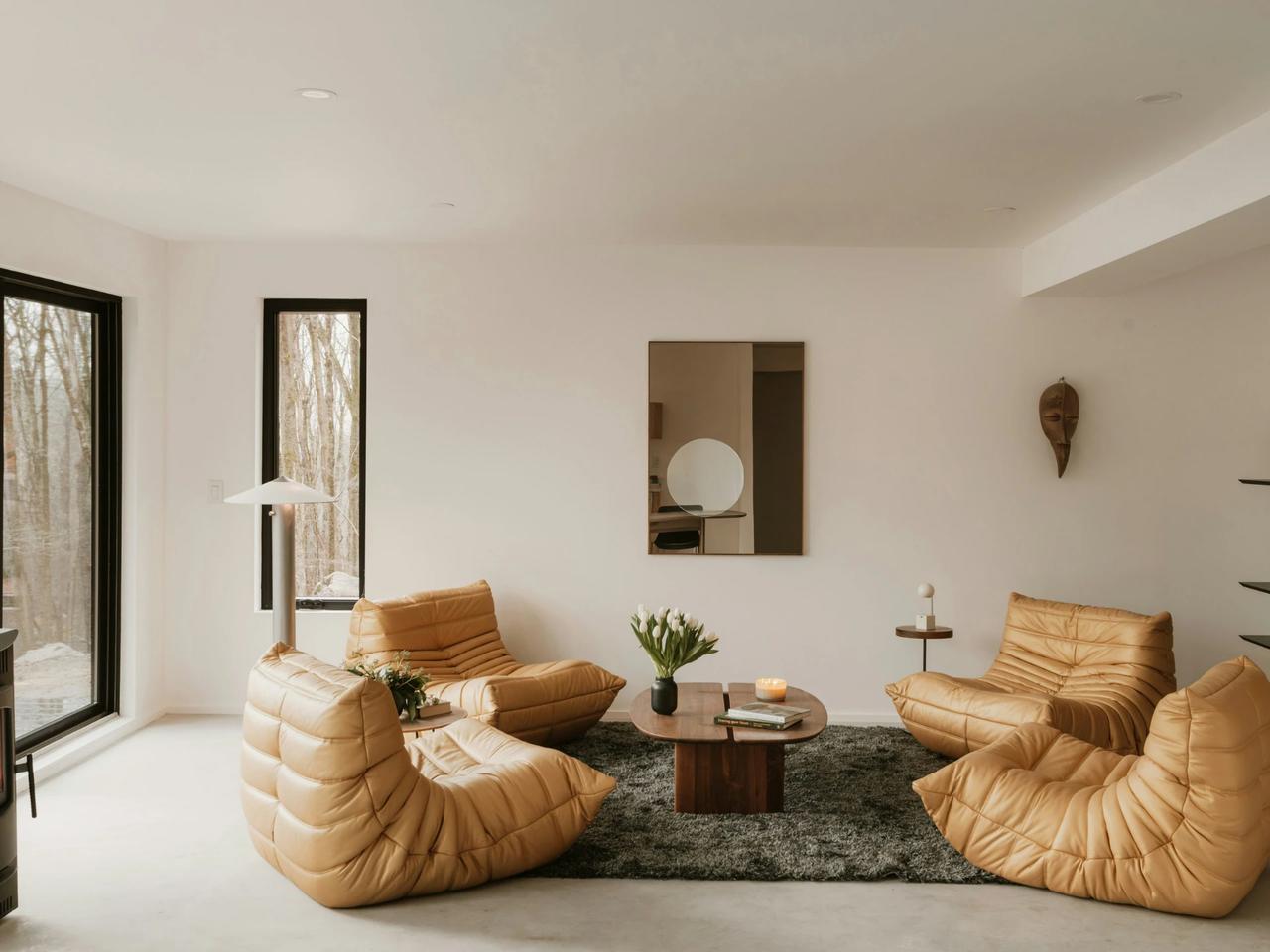 Modern living room with unique yellow chairs and a round table.