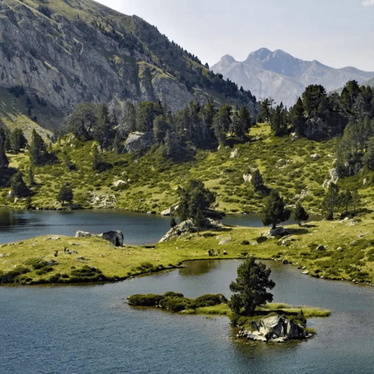 Lac entouré de collines verdoyantes et de montagnes majestueuses.
