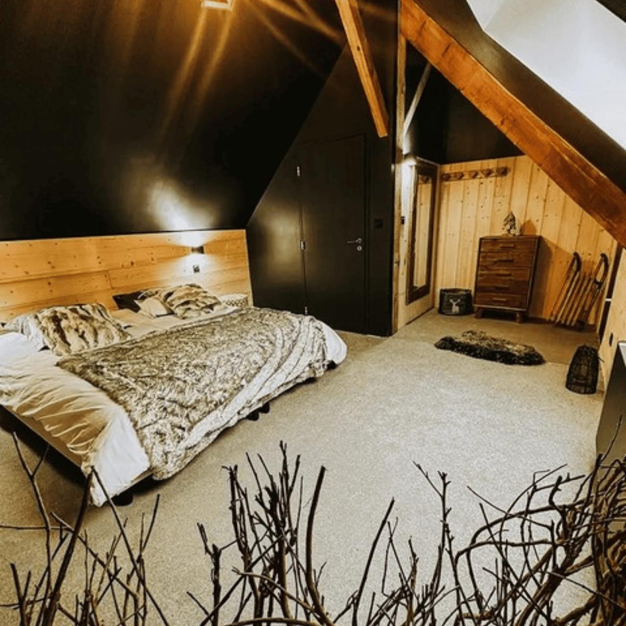 Chambre moderne avec un lit double et des murs en bois.