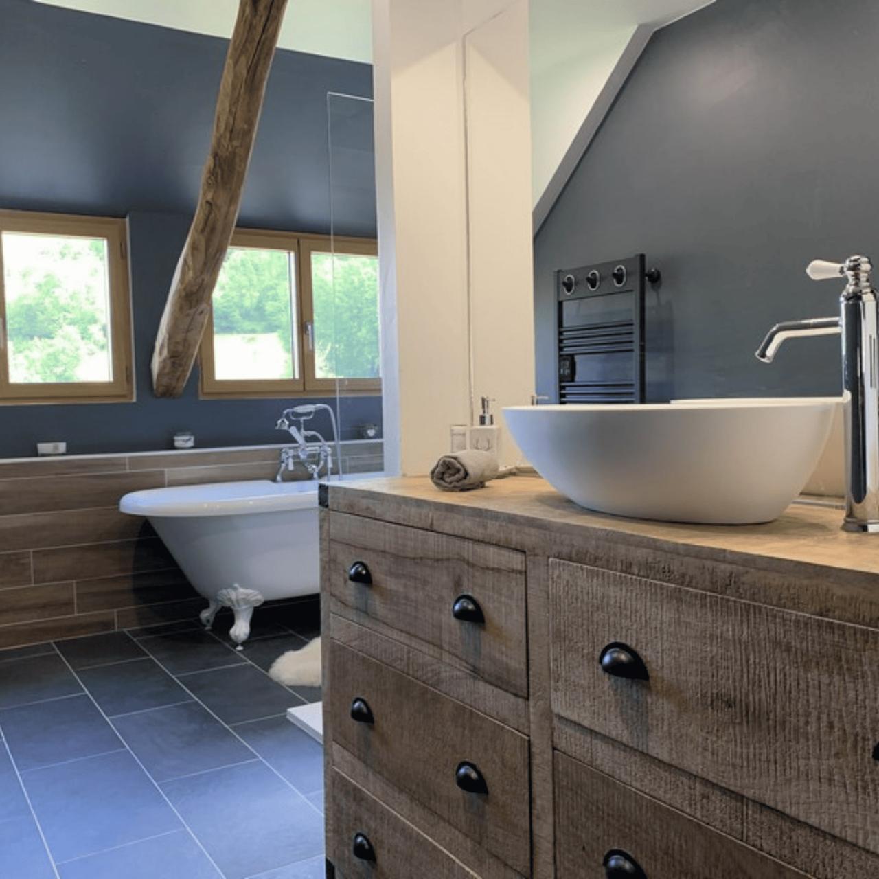Salle de bain moderne avec baignoire et lavabo sur meuble en bois