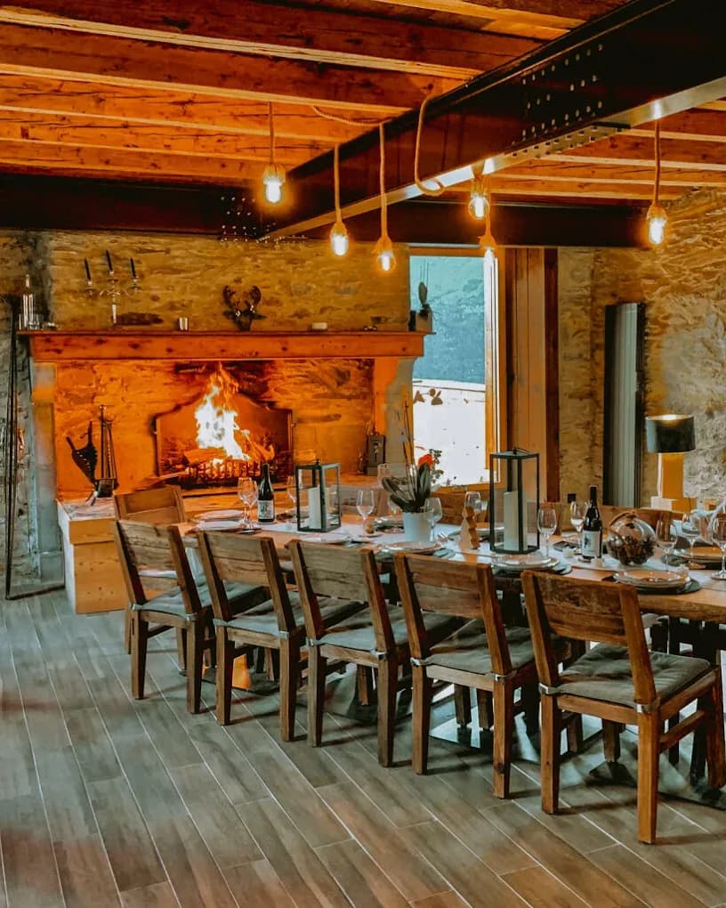 Salle à manger chaleureuse avec une grande table en bois et une cheminée.