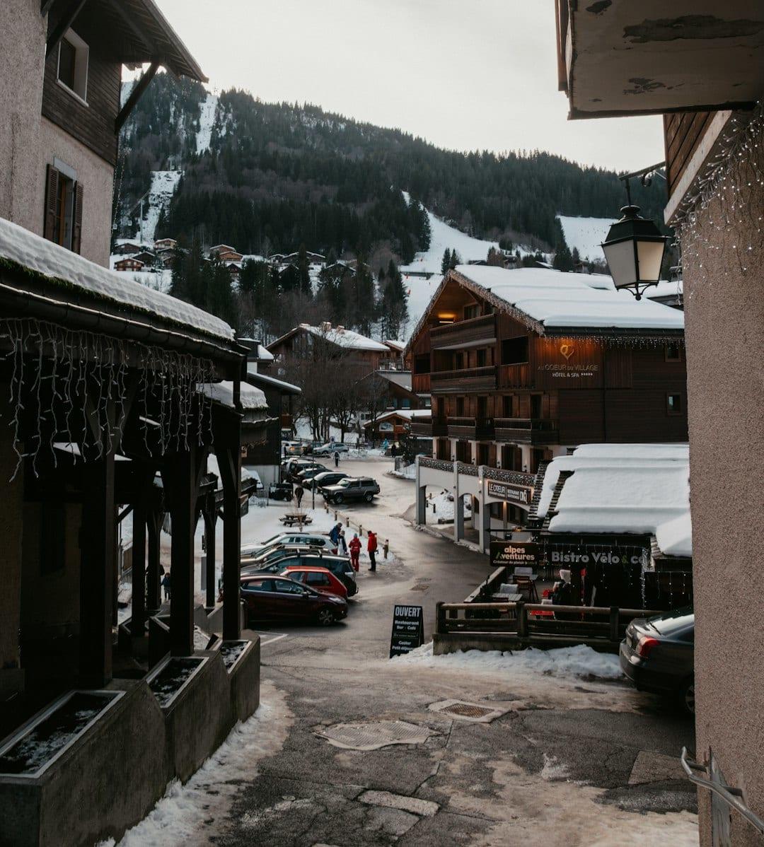 Snowy village street with ski slopes on mountain  KFr2HOIXitM