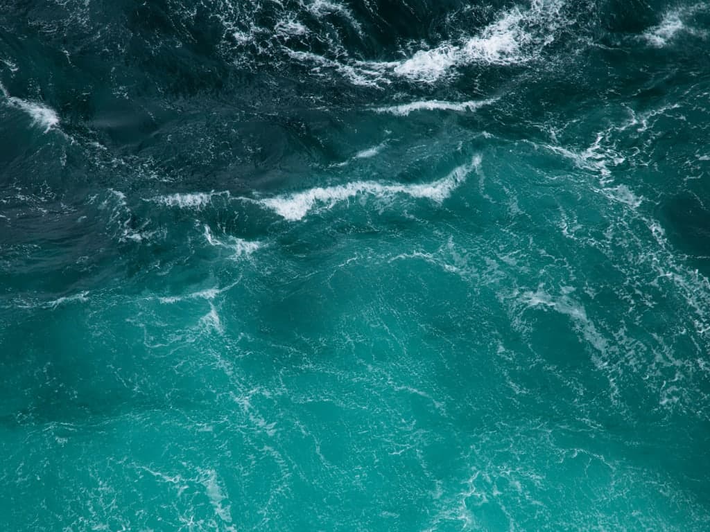 Turquoise ocean water with white foamy waves.
