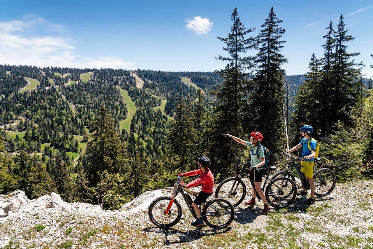 Trois cyclistes admirant le paysage montagneux à Autrans.
