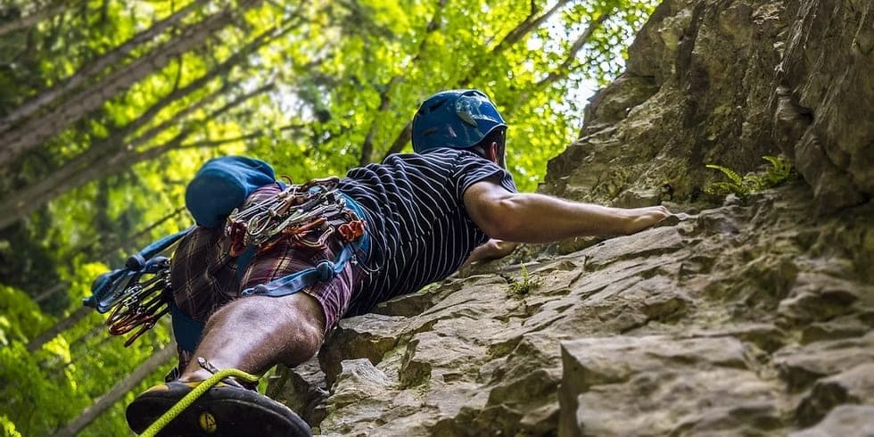 Un grimpeur escaladant une paroi rocheuse en pleine nature.
