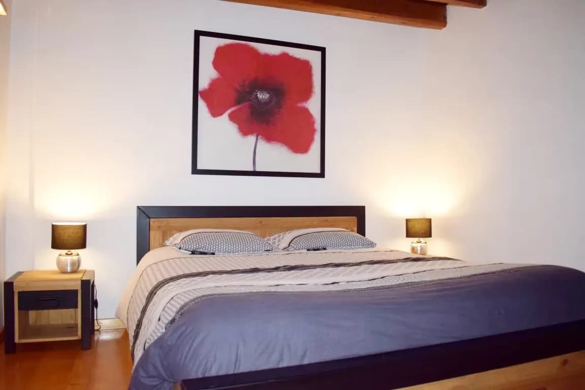 Chambre avec lit double et tableau de coquelicot rouge.