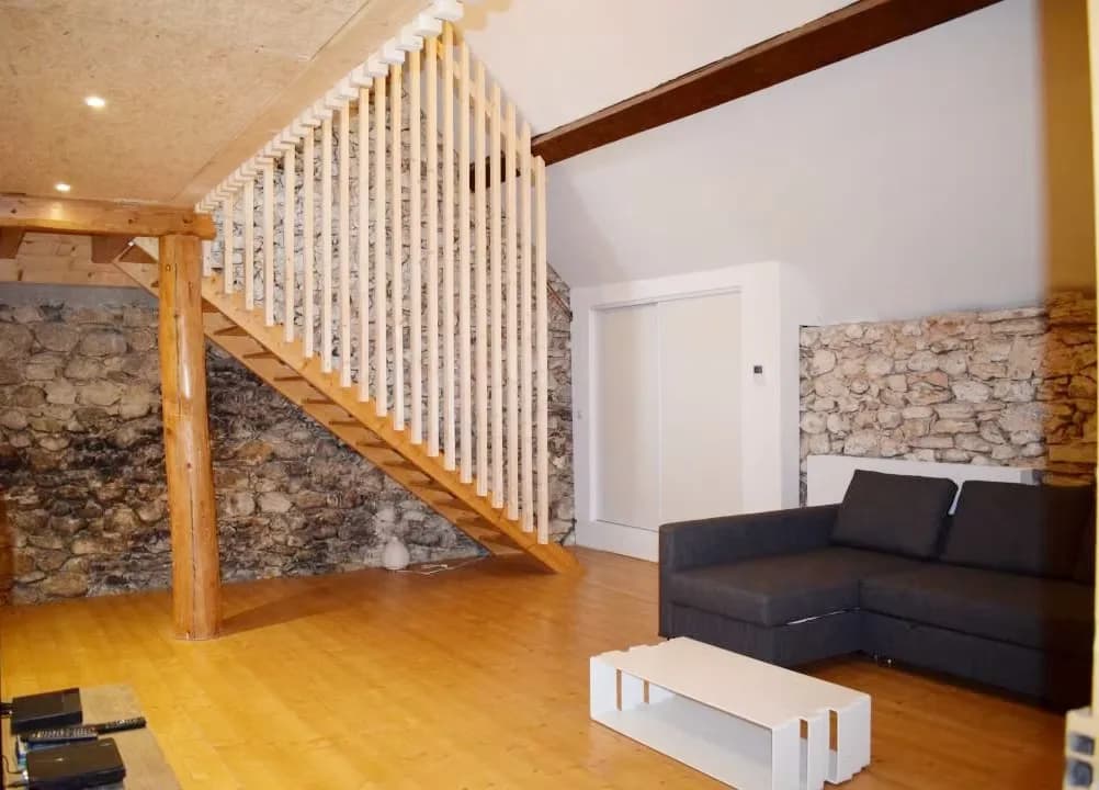 Intérieur d'un salon avec un canapé et un escalier en bois