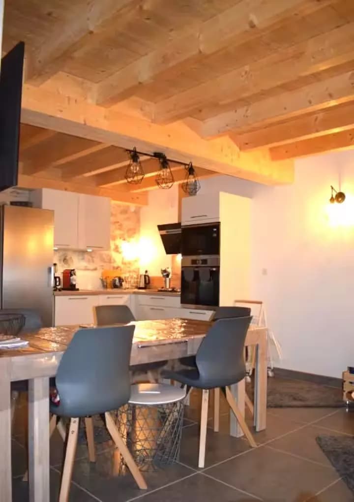 Cuisine moderne avec un plafond en bois et un espace repas.