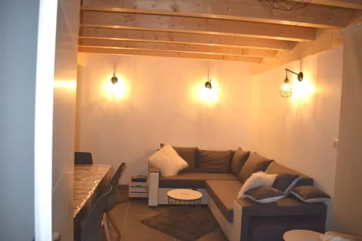 Intérieur d'un salon moderne avec un canapé et des lumières suspendues.