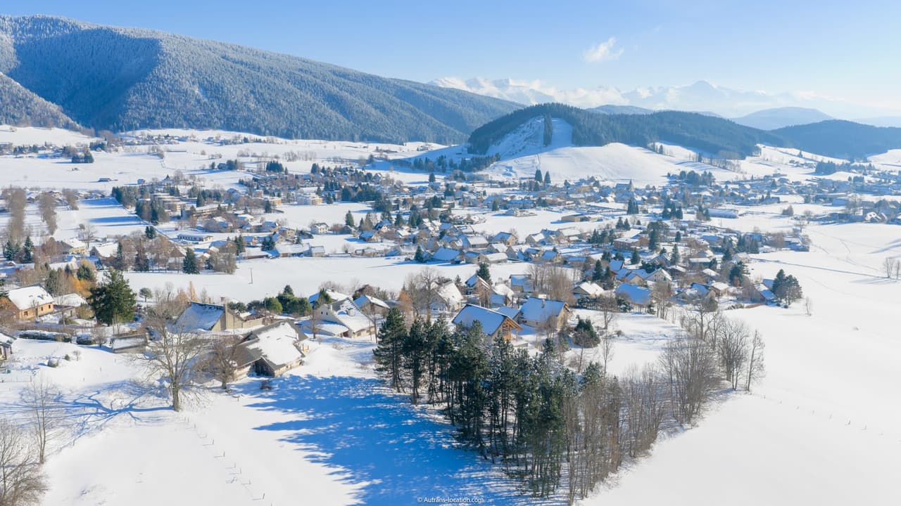Vue panoramique d'Autrans recouvert de neige en hiver.