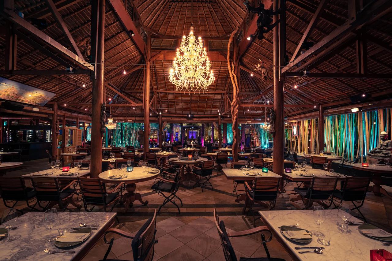 Interior view of a restaurant with wooden beams and chandeliers.