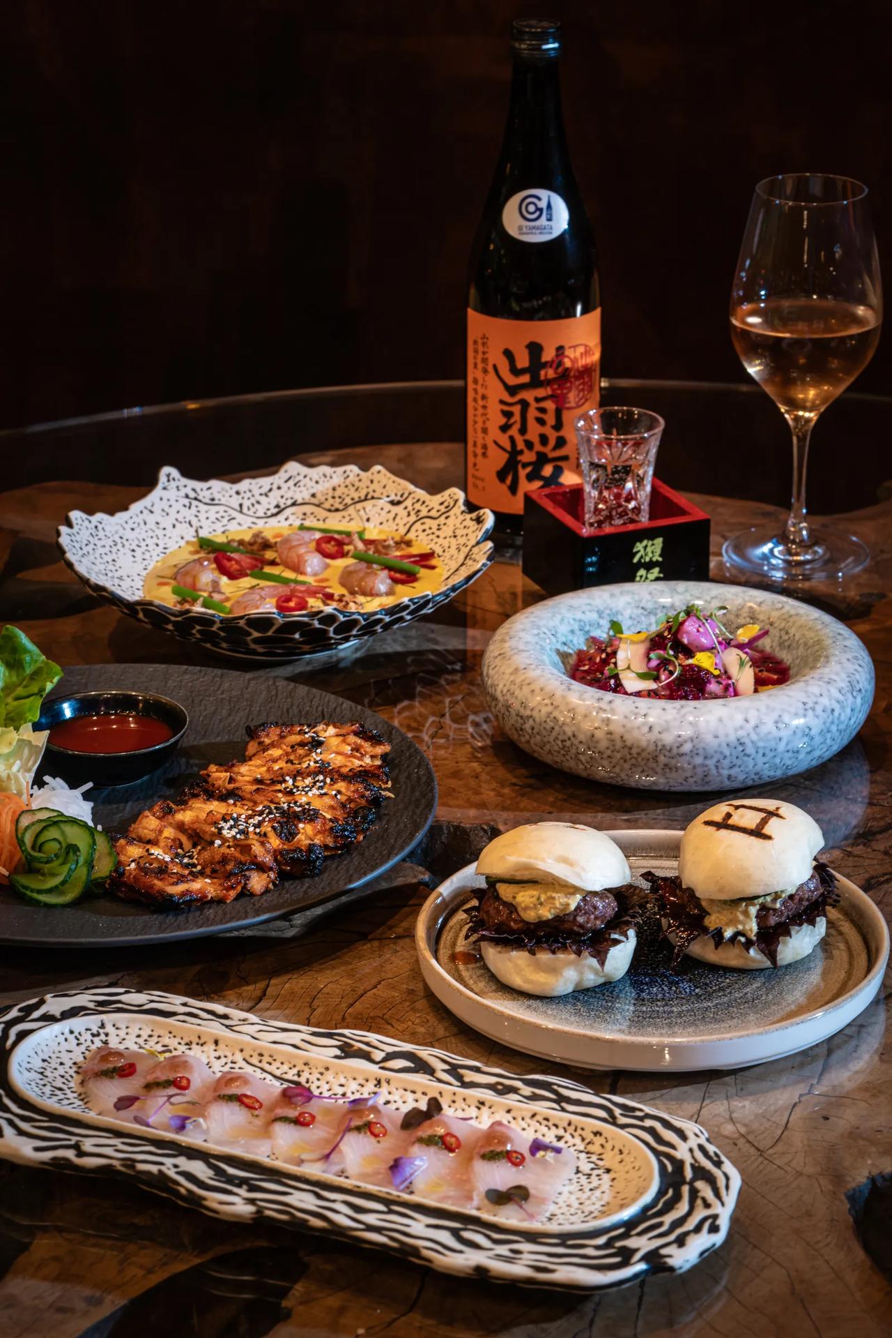 A variety of beautifully presented dishes and drinks on a wooden table.