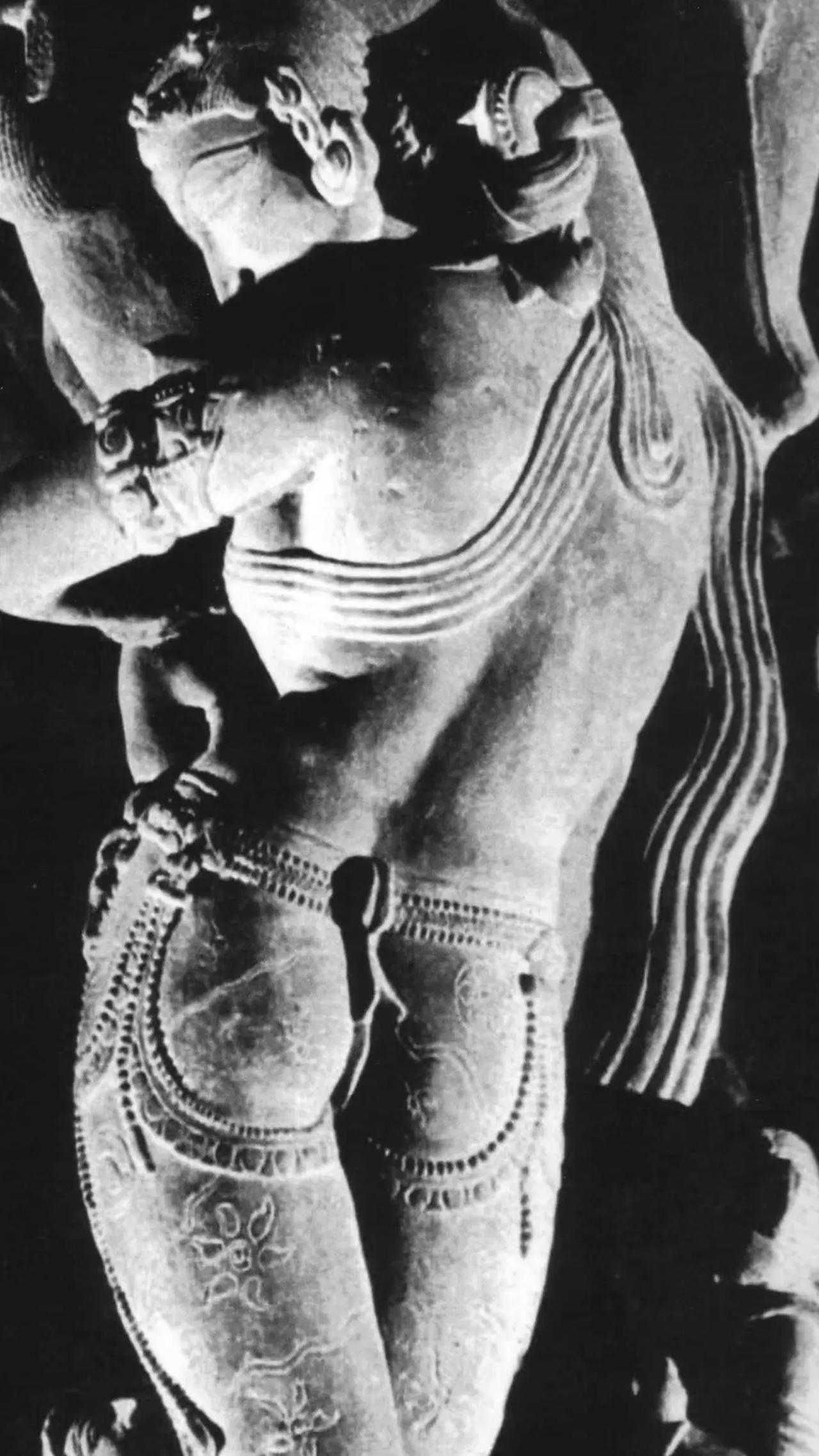 Sculpture of a figure with intricate details and flowing hair.