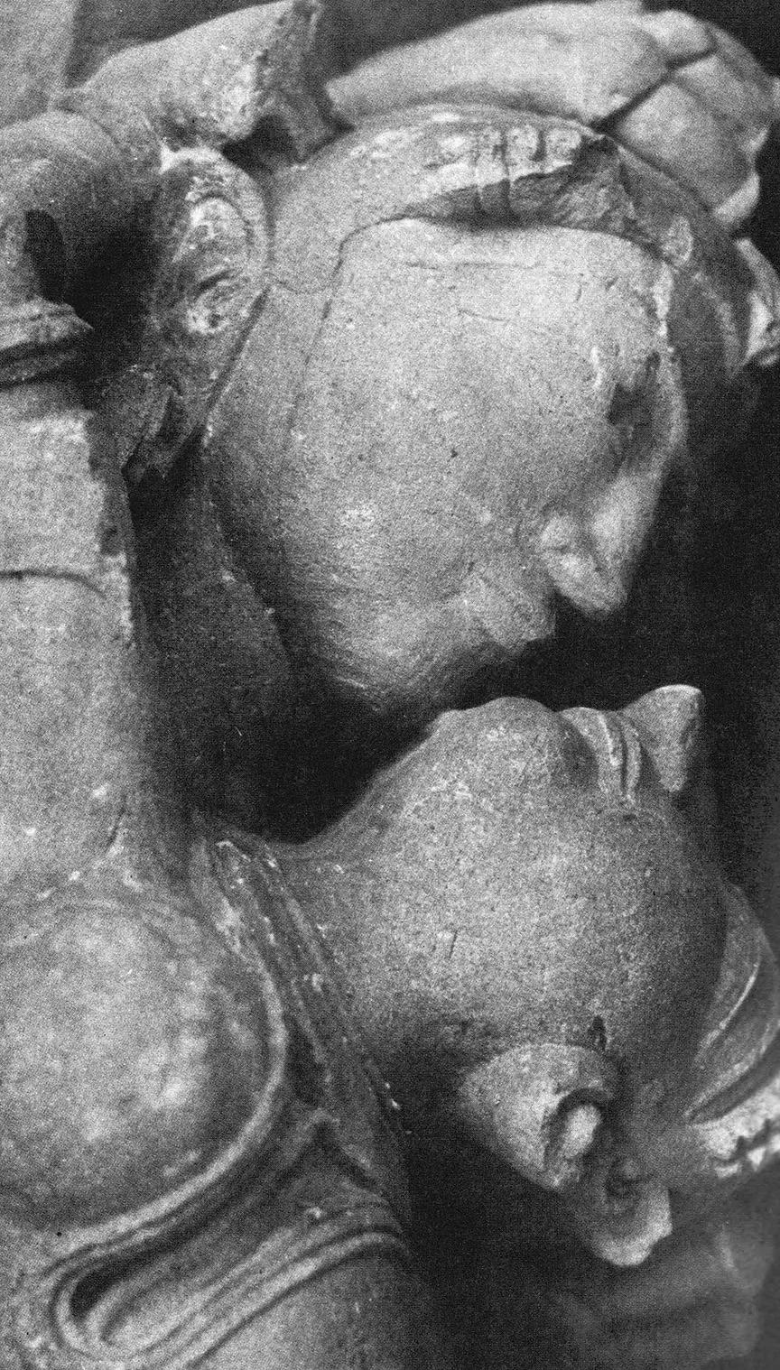 Close-up of two intertwined figures in a stone sculpture.