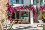 Outdoor dining area with pink flowers and pool view